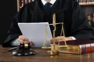 Executor, Judge reading and reviewing documents at a desk with a law book, legal scale and gavel Executor duties