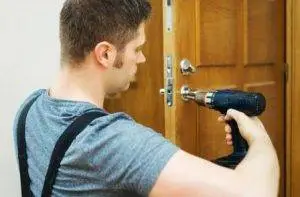 Sheriff Eviction, Man with a power screwdriver changing a front door lock Sheriff Eviction, Changing locks at a Sheriff's Eviction